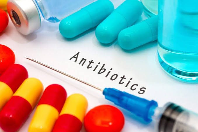 A selection of antibiotic capsules, tablets, and an injectable vial